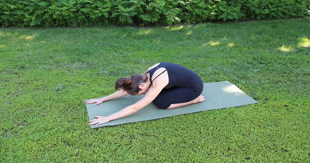 femme dans un parc faisant la position du coquillage en yoga
