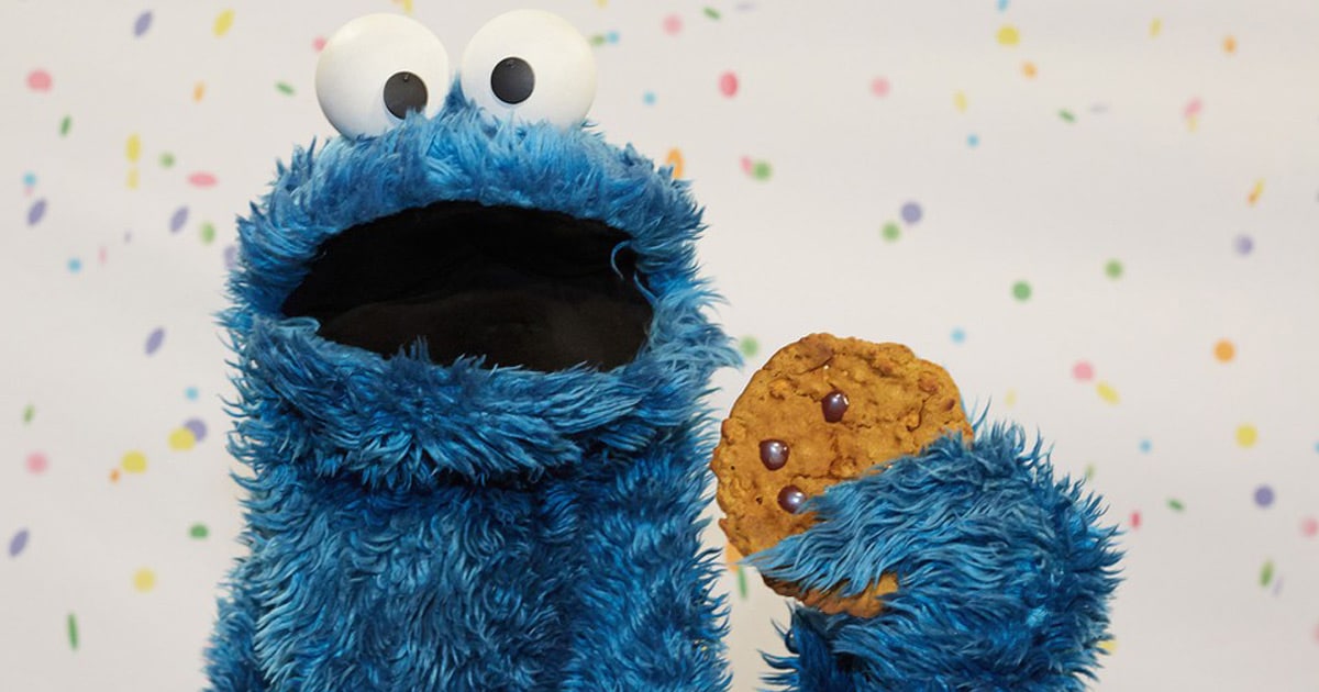Monstre bleu avec biscuit aux pépites de chocolat dans la main